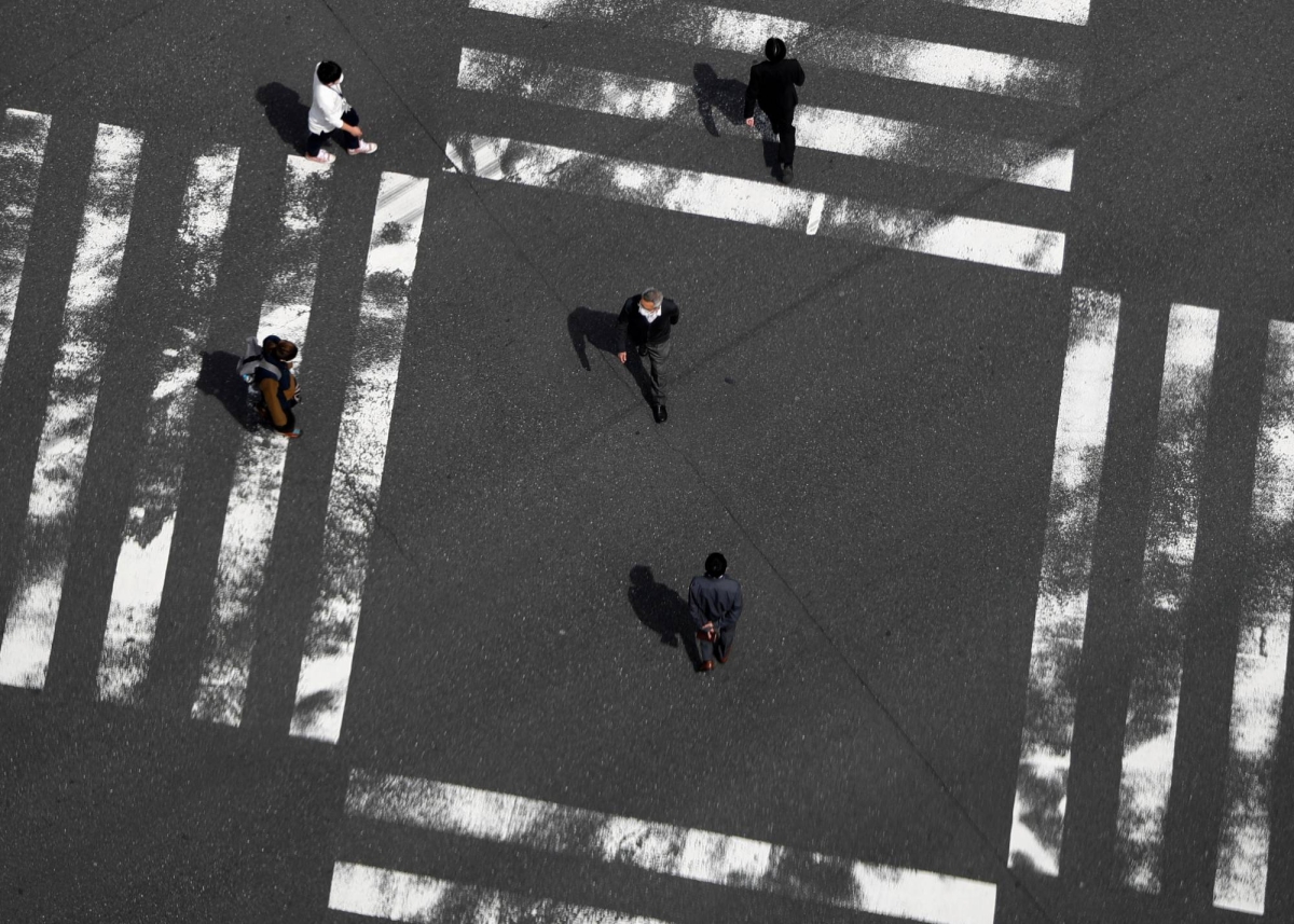 Japan says overall economy recovering, but cuts view on corporate profits